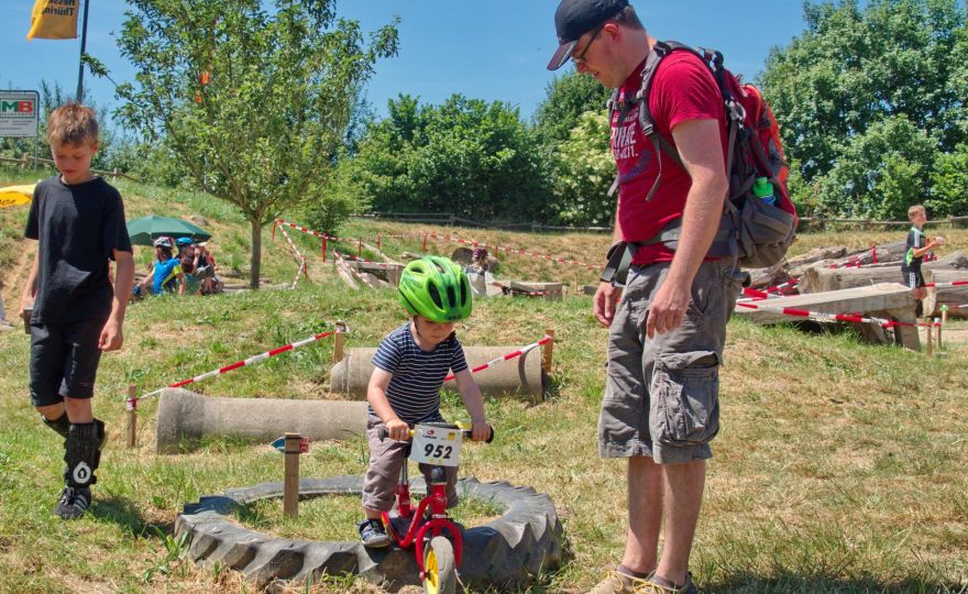 Ein kleines Kind mit Helm übt sich als Trial-Fahrer
